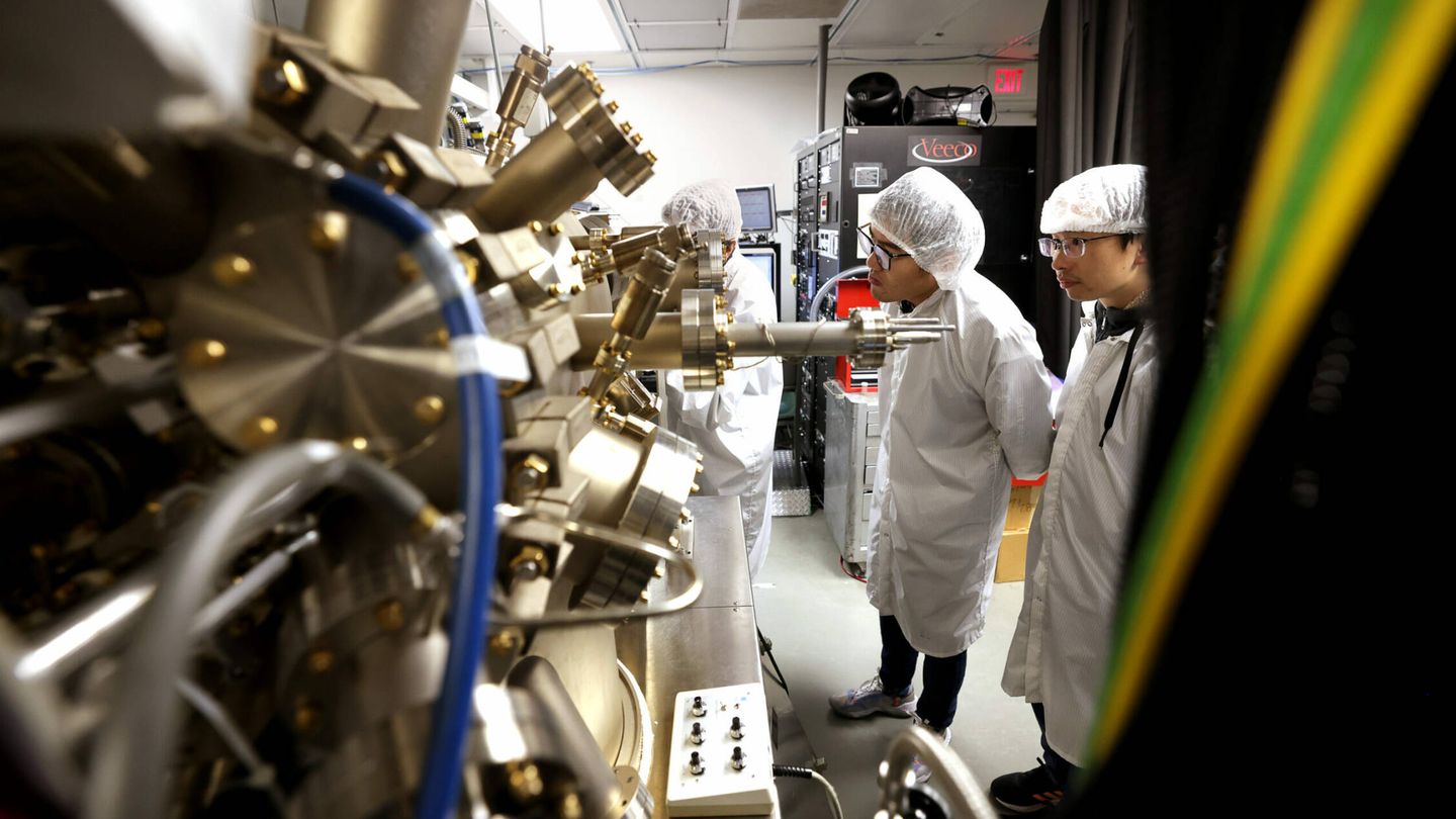 Los investigadores observan la máquina en la que se cultivan los nanocables semiconductores. (MU)