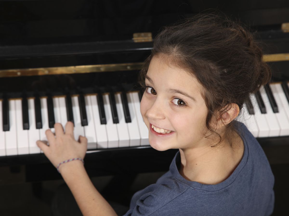 Foto: Vista de una niña tocando el piano. (iStock)