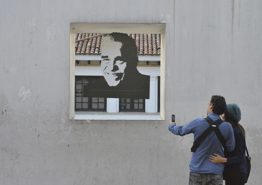 Foto: Una pareja toma una foto de un retrato de Gabo, en Bogotá. (AP)
