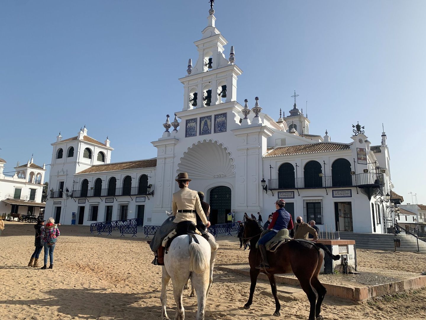 Un grupo de personas pasea a caballo por la aldea de El Rocío este pasado fin de semana. (EFE/Fermín Cabanillas)