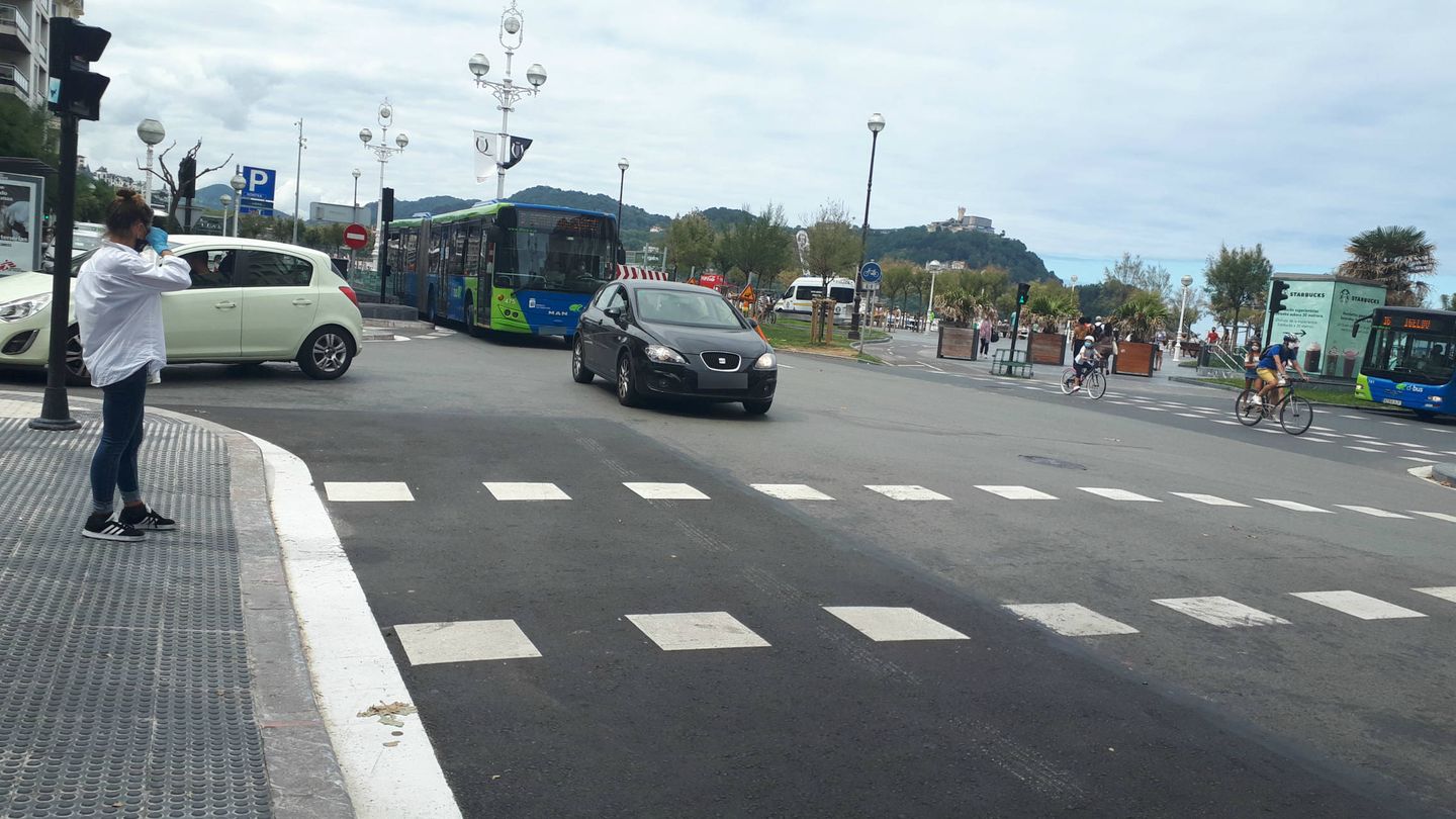 Un vehículo no cumple con la obligación de girar a la derecha y circula recto seguido de un autobús urbano. Al fondo, una unidad móvil de la Policía Local. (J. M. A.) 