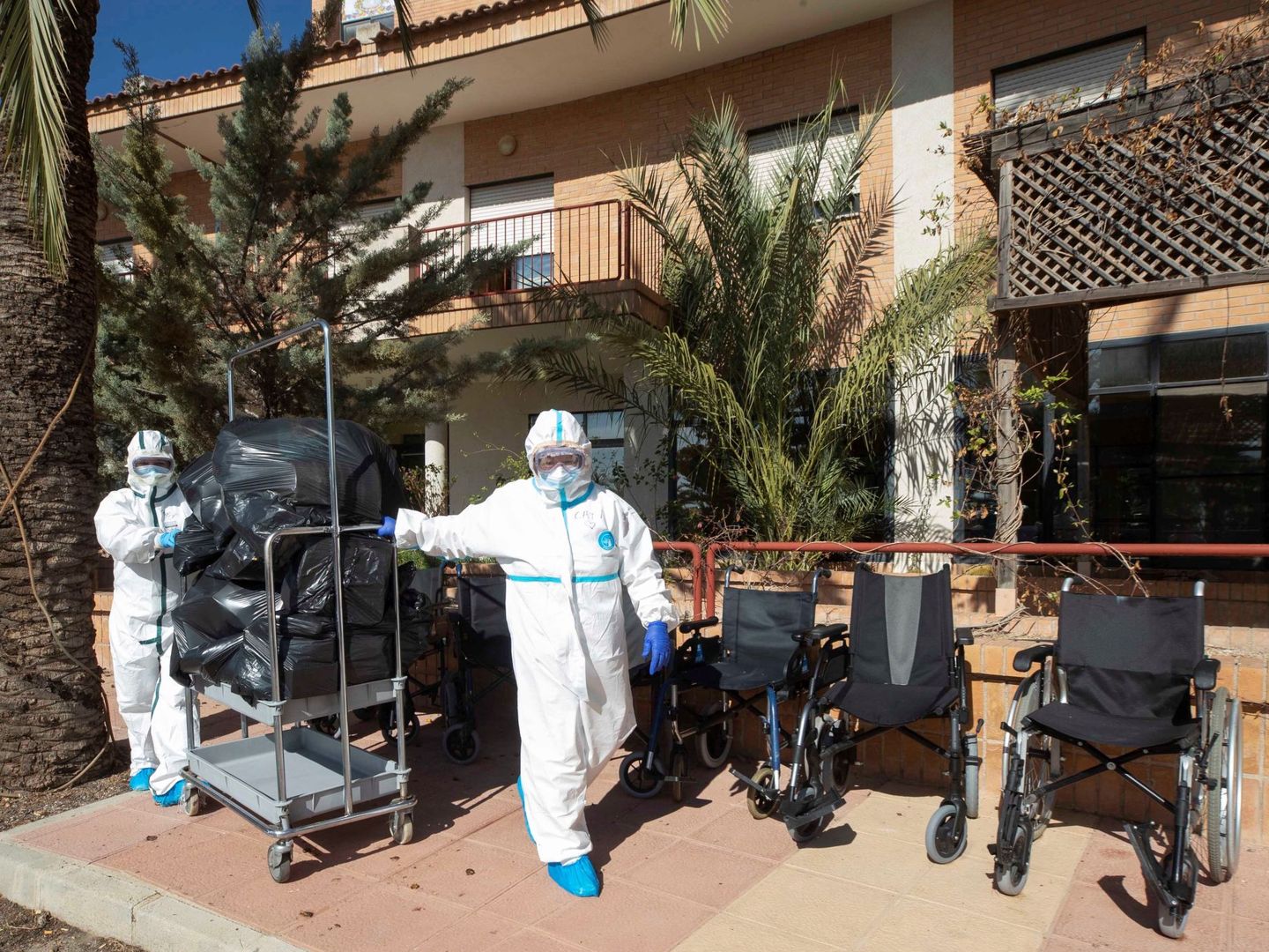 Trabajadoras equipadas con trajes de protección, durante las labores de desinfección de una residencia de ancianos. (EFE) 