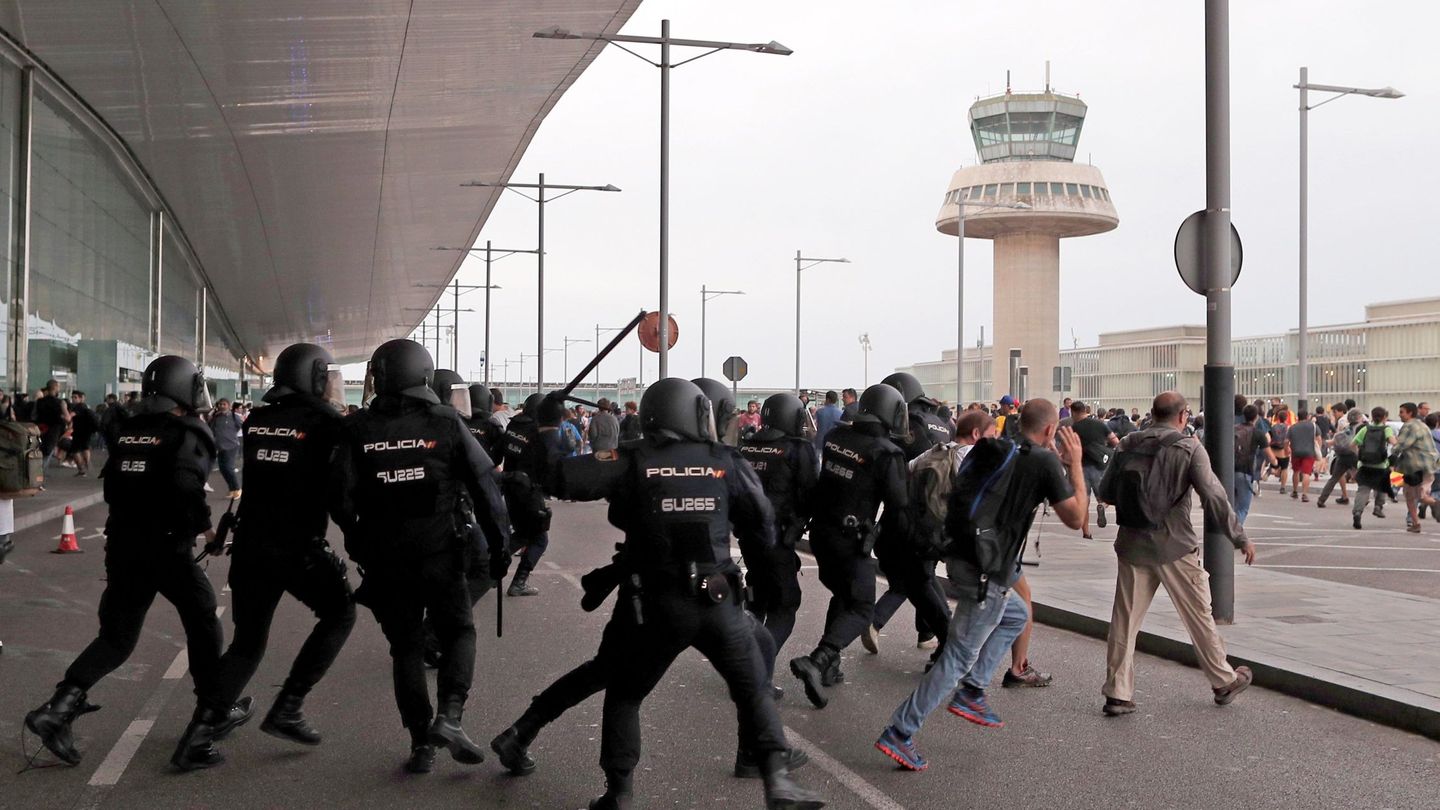 Miembros de la Policía Nacional cargan contra los centenares de personas que se agolpaban ante el Aeropuerto del Prat. (EFE)