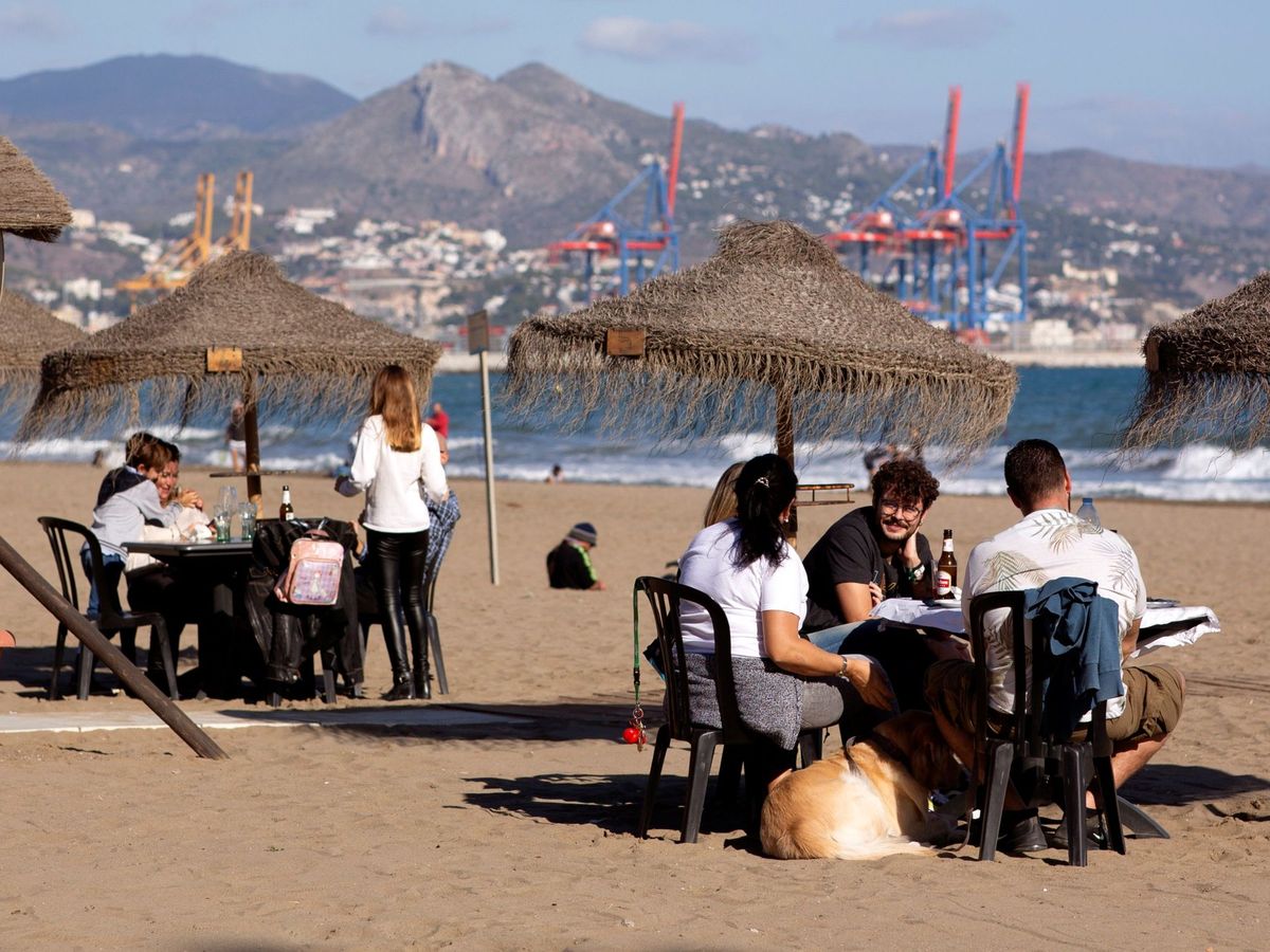 Foto: Varias personas toman algo en un chiringuito en Málaga. (EFE/Carlos Díaz)