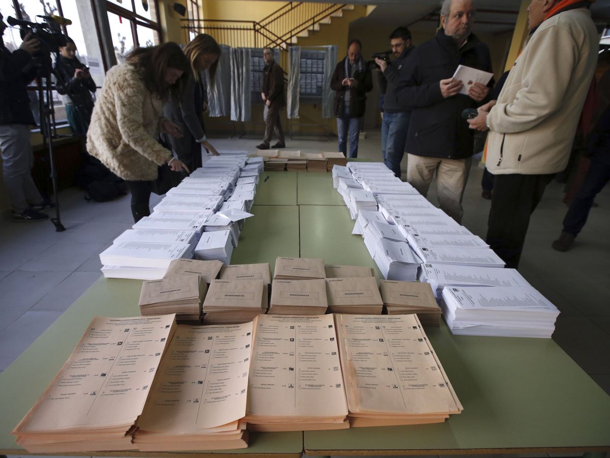 Foto: Papeletas de los diferentes partidos políticos dispuestas en un colegio electoral para ser recogidas por los votantes. (EFE)