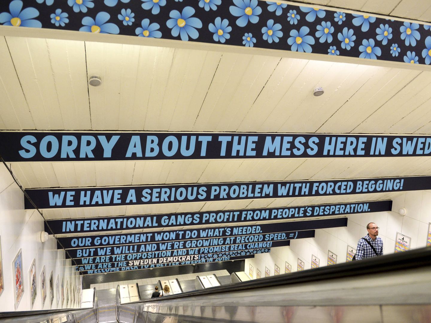 Un hombre pasa bajo un cartel del SD en el metro de Estocolmo. (Reuters)
