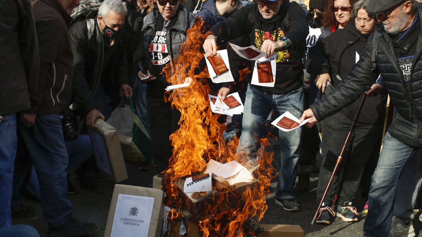 Miembros de los comités de defensa de la república (CDR) queman banderas y ejemplares de la Constitución. (EFE/Marta Pérez)