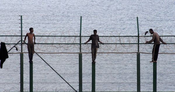 Foto: Tres inmigrantes subsaharianos permanecen este viernes en la valla fronteriza de Ceuta con Marruecos. (EFE)