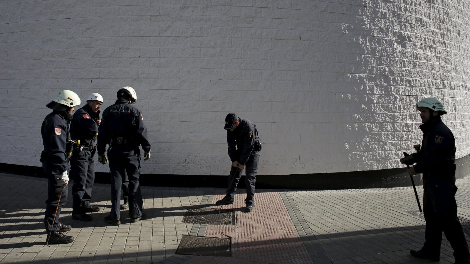 Foto: Varios policías comprueban minuciosamente las alcantarillas anexas al Bernabéu (Reuters).