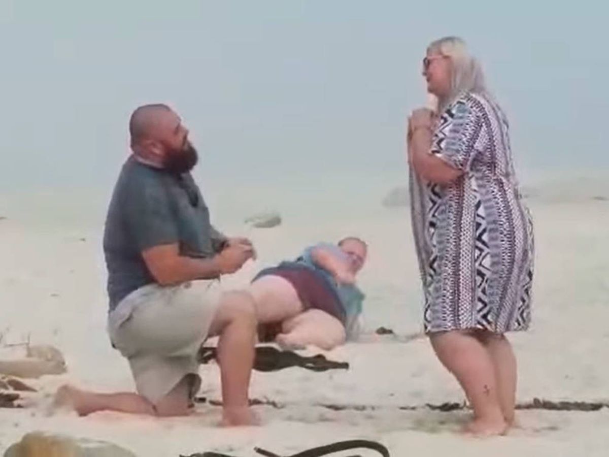 Foto: Mientras la pareja se pedía en matrimonio, la hermana se revuelca por la arena (Facebook)