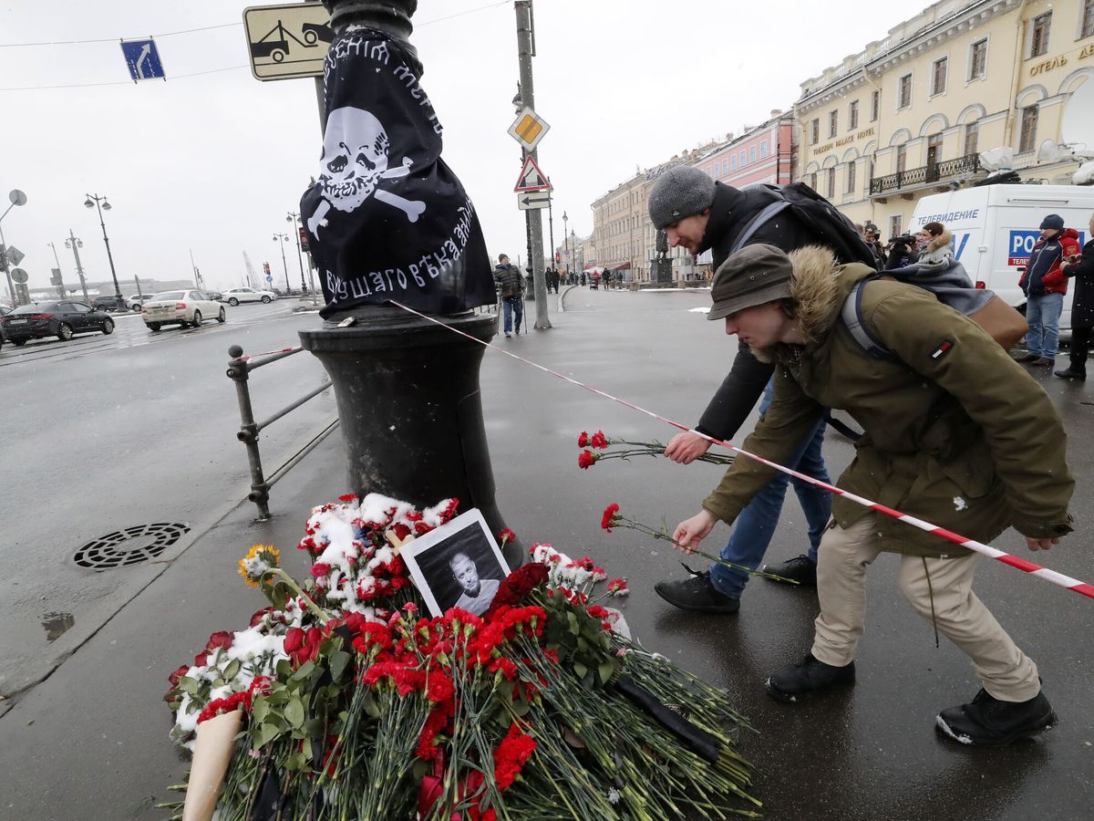 Foto: Dos hombres dejan un par de claveles junto a una farola, memorial improvisado por el bloguero militar ruso Vladlen Tatarsky. (EFE/Anatoly Maltsev)