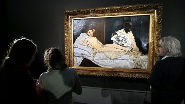 Varias personas observan la obra 'Olympia' de Manet. (EFE/Yuri Kochetkov)
