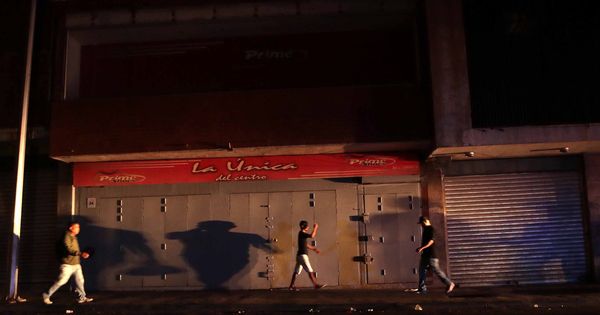 Foto: Un grupo de personas camina por las calles de Caracas a oscuras, este jueves. (EFE)