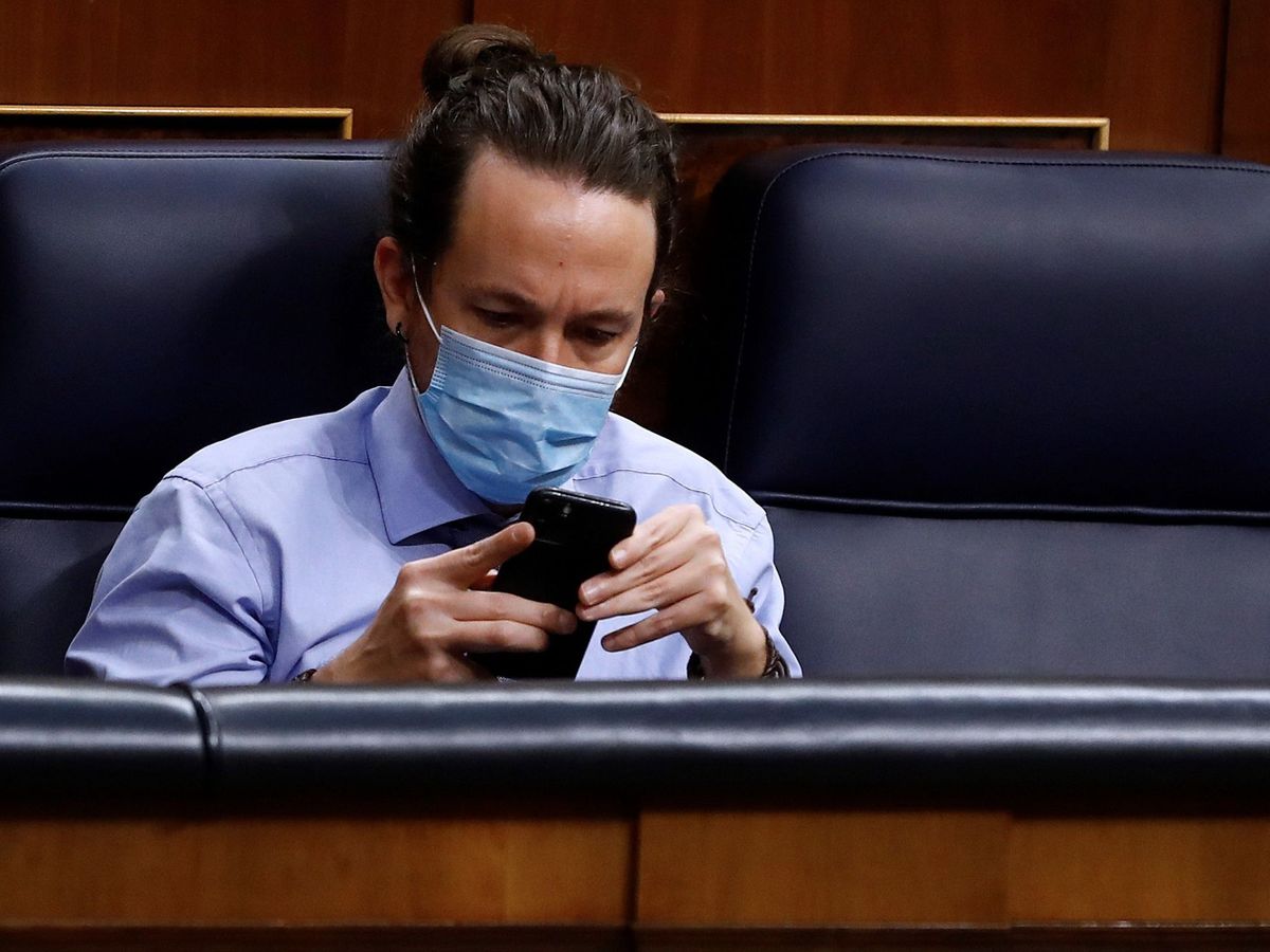 Foto: Pablo Iglesias consulta su teléfono desde su escaño del Congreso. (EFE)