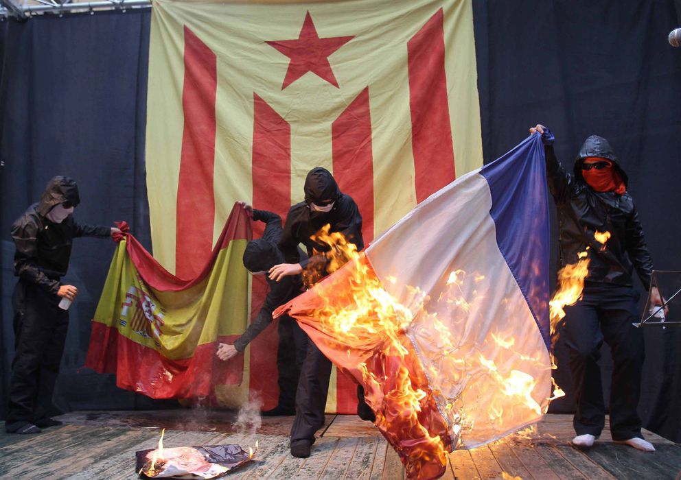 Foto: Encapuchados queman las banderas de España y Francia al acabar una manifestación independentista. (EFE)