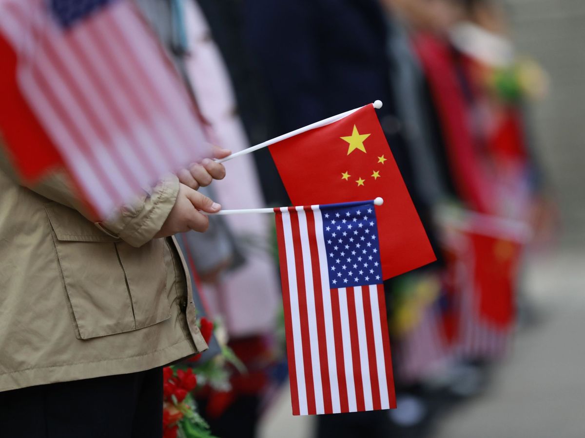 Foto: Niños que sostienen banderas de Estados Unidos y China. (EFE/Xinhua)