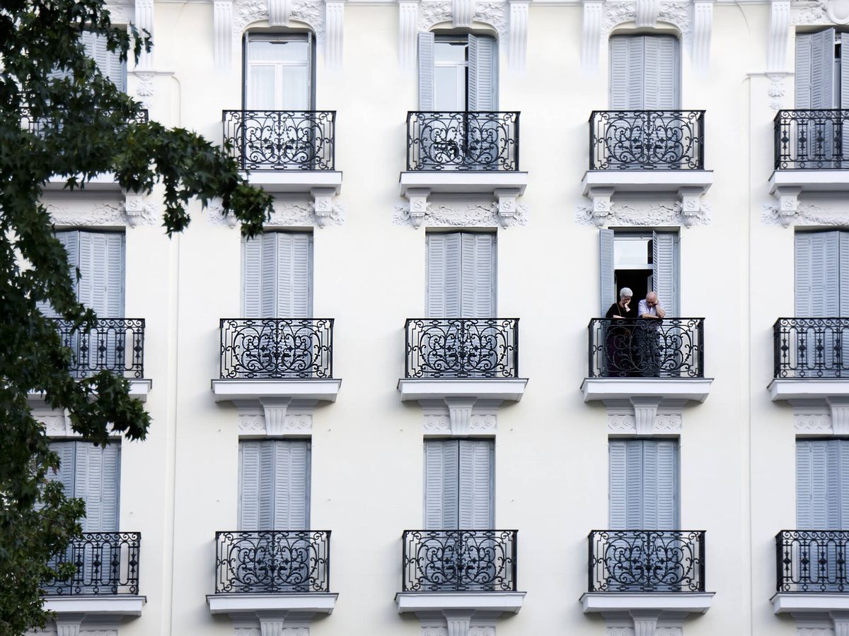 Foto: Dos vecinos de Madrid asomados en su balcón. (Foto: iStock)