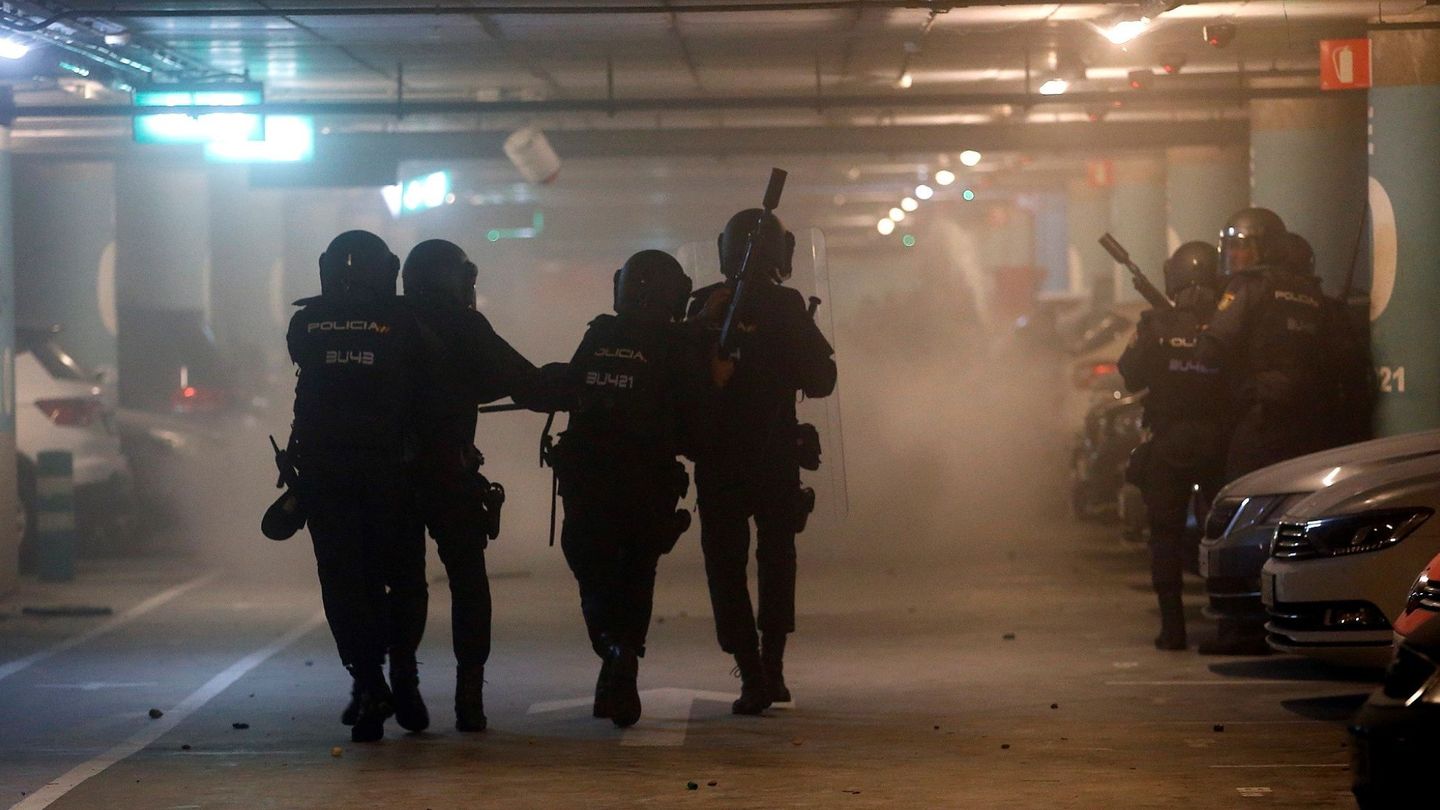 Miembros de la Policía Nacional cargan contra manifestantes este lunes en el parking del Aeropuerto de El Prat. (EFE)