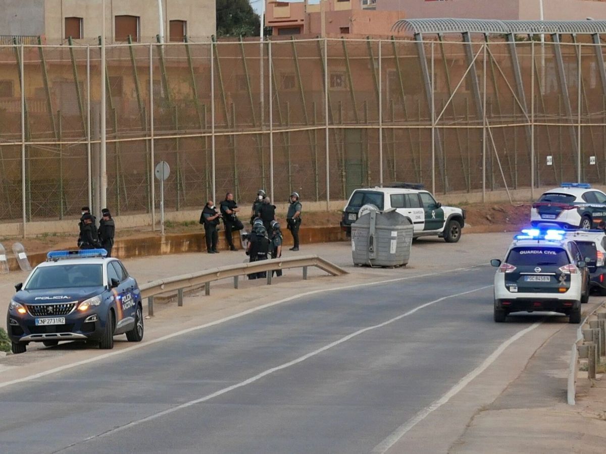 Foto: Vista de varias patrullas y agentes de la Guardia Civil y de la Policía Nacional en la zona cercana al paso fronterizo de Barrio Chino en Melilla. (EFE/Paqui Sánchez)