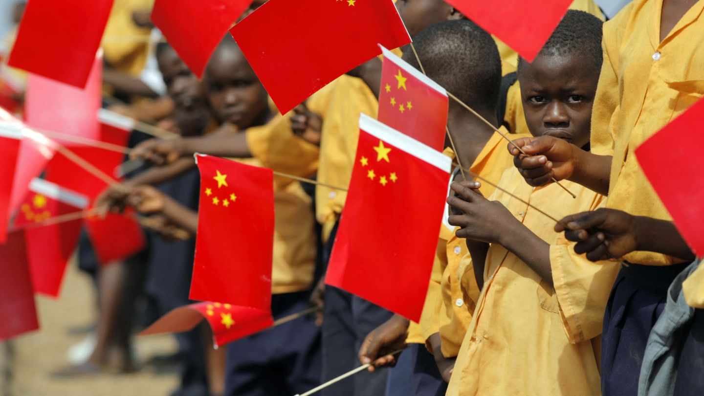 Niños liberianos agitan banderas chinas para recibir al expresidente Hu Jintao (Reuters).
