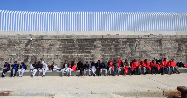Foto: Inmigrantes esperan en el puerto de Tarifa (Cádiz) a ser trasladados por la Guardia Civil tras ser atendidos por Cruz Roja. (EFE)