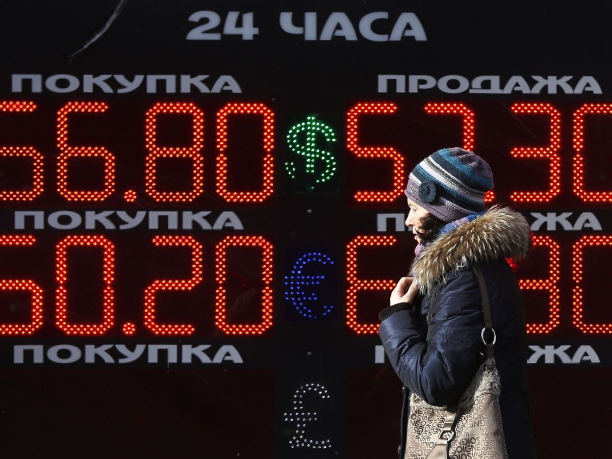 Foto: Una mujer camina delante de una pantalla de información de una tienda de cambio de divisas en Moscú. (EFE/Yuri Kochetkov)