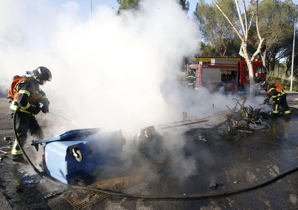 Foto: Bomberos proceden a apagar los contenedores incendiados y utilizados como barricadas (Efe)