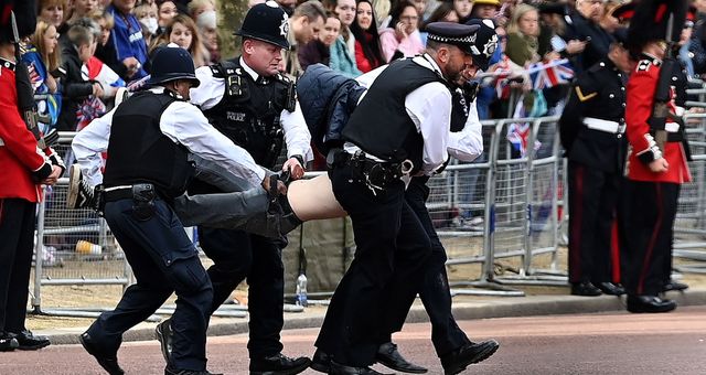 La policía retira a un hombre que protestaba por la celebración del jubileo. (EFE/Andy Rain)