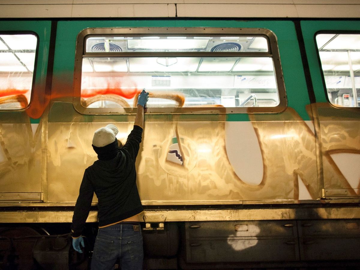 Foto: Grafitero en una cochera pintando un metro en imagen de archivo. (EFE/Enrique Escandell)