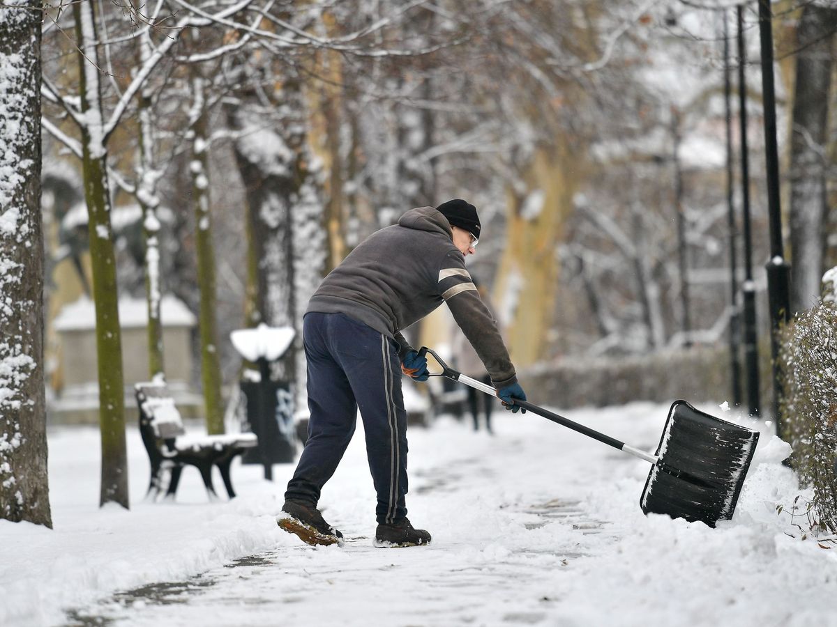 Foto: Un hombre retira con una pala la nieve. (EFE)