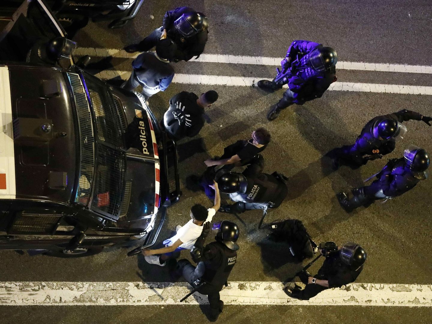 Un grupo de policías proceden a registrar a dos jóvenes ayer en Barcelona. (EFE)