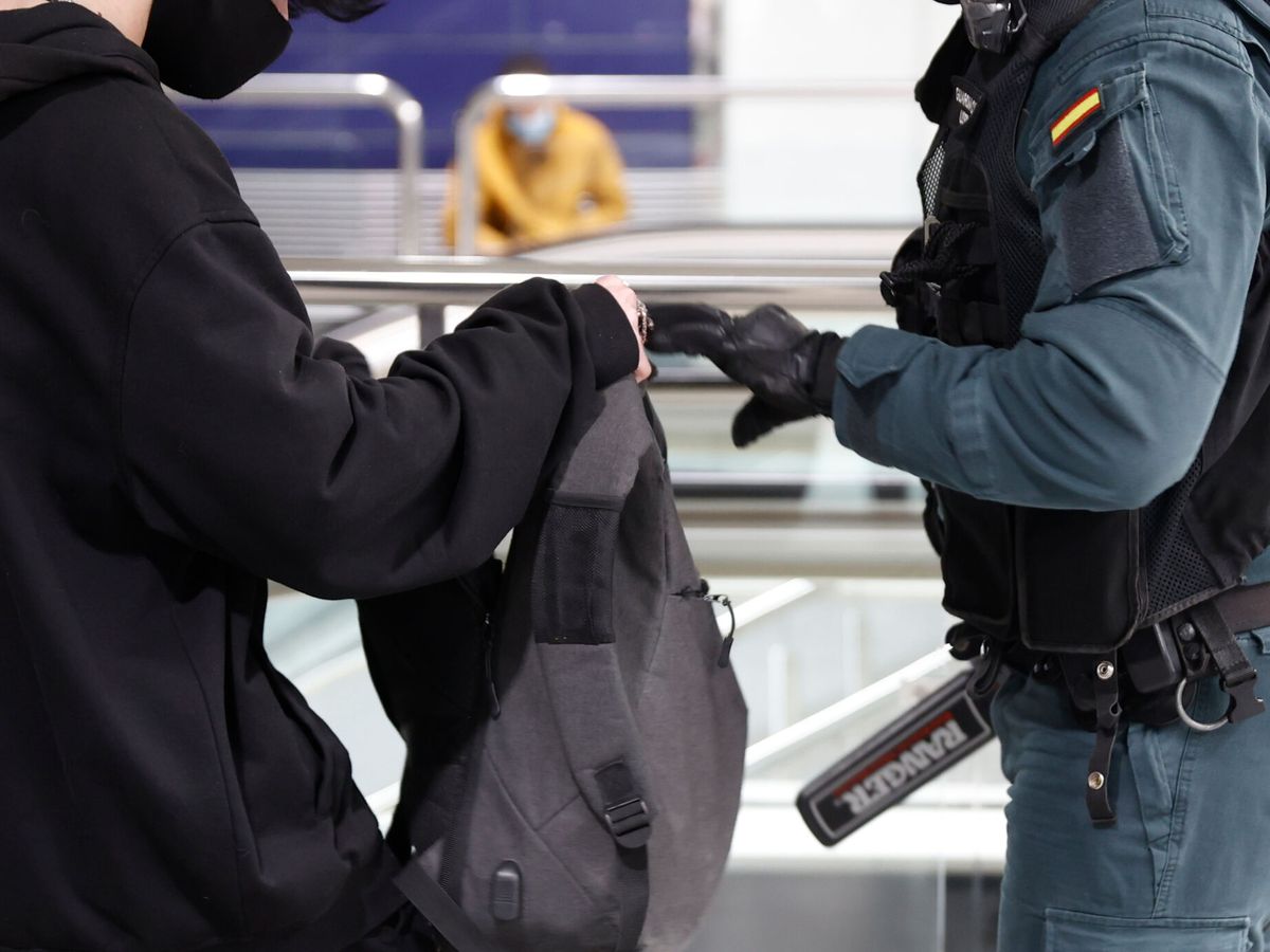 Foto: Un guardia civil revisa una mochila en el marco del operativo contra las bandas juveniles desplegado en Madrid. (EFE/Mariscal)