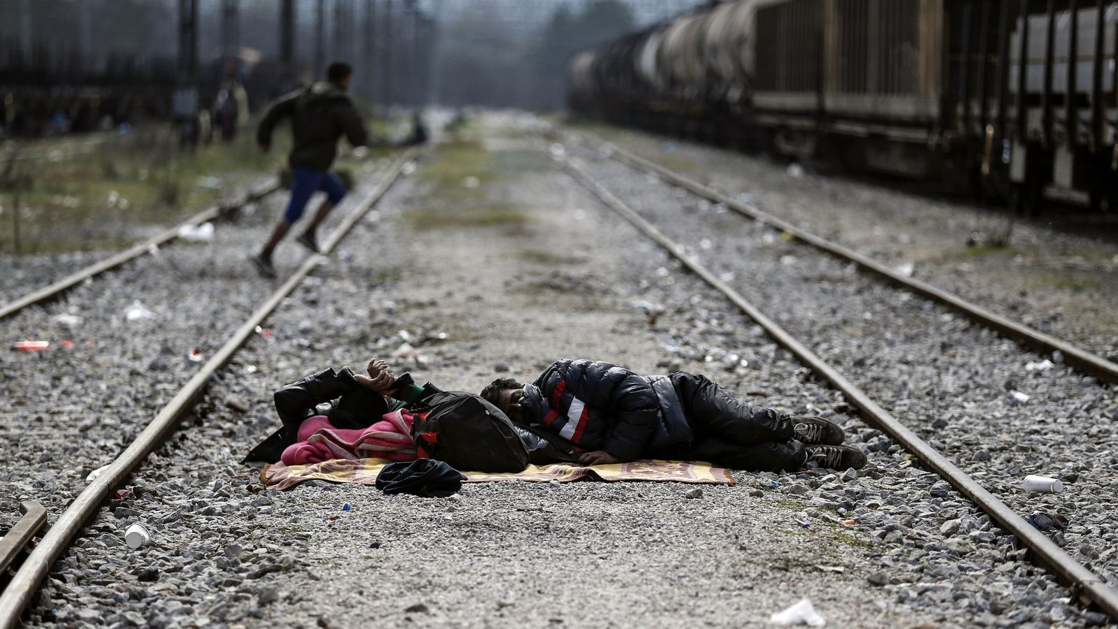 Foto: Dos refugiados duermen en una vía de tren cerca de la frontera entre Grecia Y Macedonia, en Idomeni (Reuters).