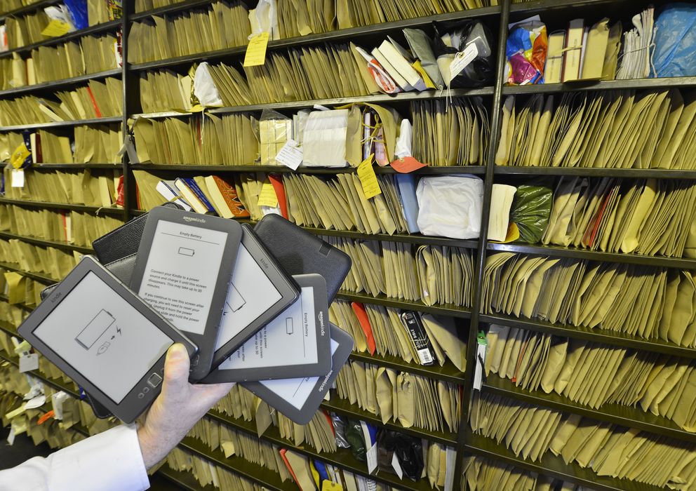 Foto: E-books frente a una estantería de libros enviados en una oficina de correos (Reuters)