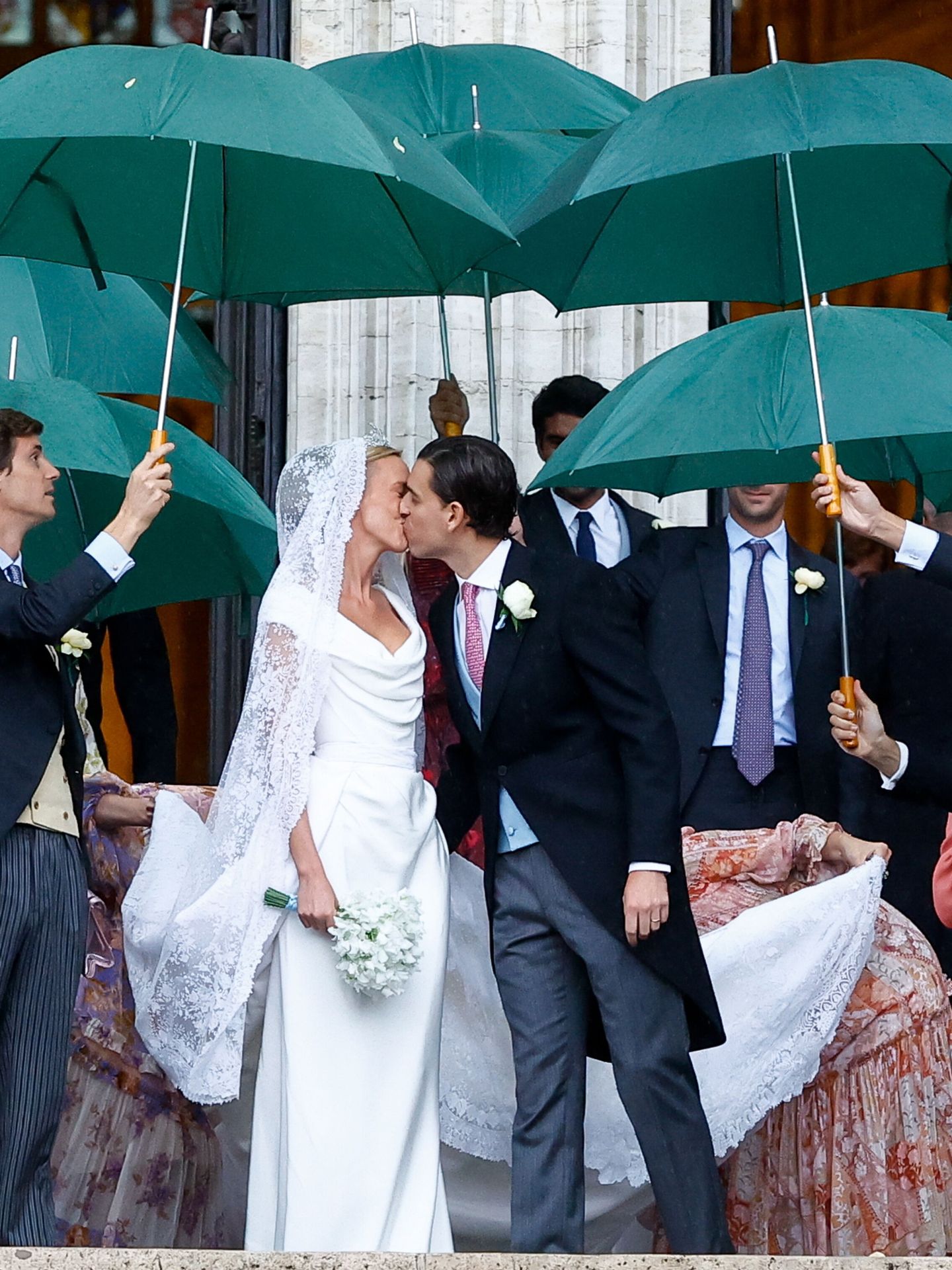 Los novios, cubiertos con paraguas. (EFE/Stephanie Lecocq)