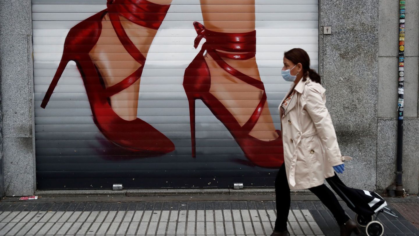 Una mujer pasa ante un comercio cerrado en Madrid. (EFE)