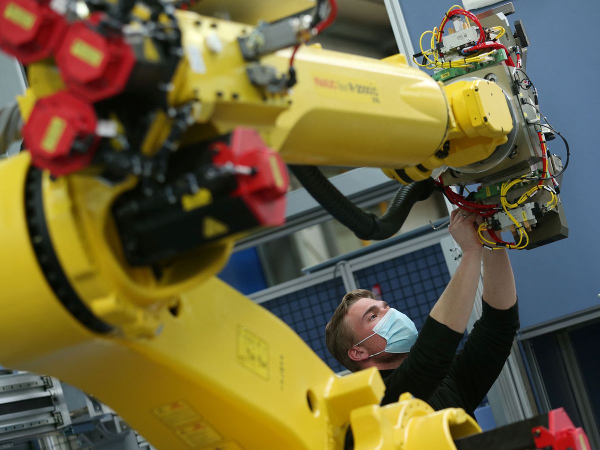Foto: Un empleado trabaja con un robot industrial en una empresa de automatización. (Reuters / Ralph Orlowski)
