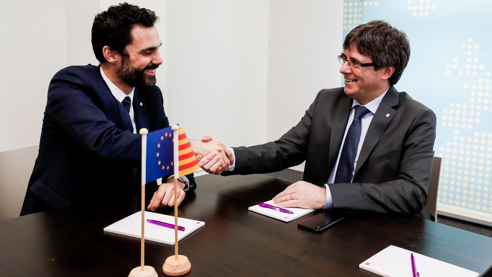 Foto: El expresidente de la Generalitat Carles Puigdemont estrecha la mano del presidente del Parlament, Roger Torrent. (Efe) 