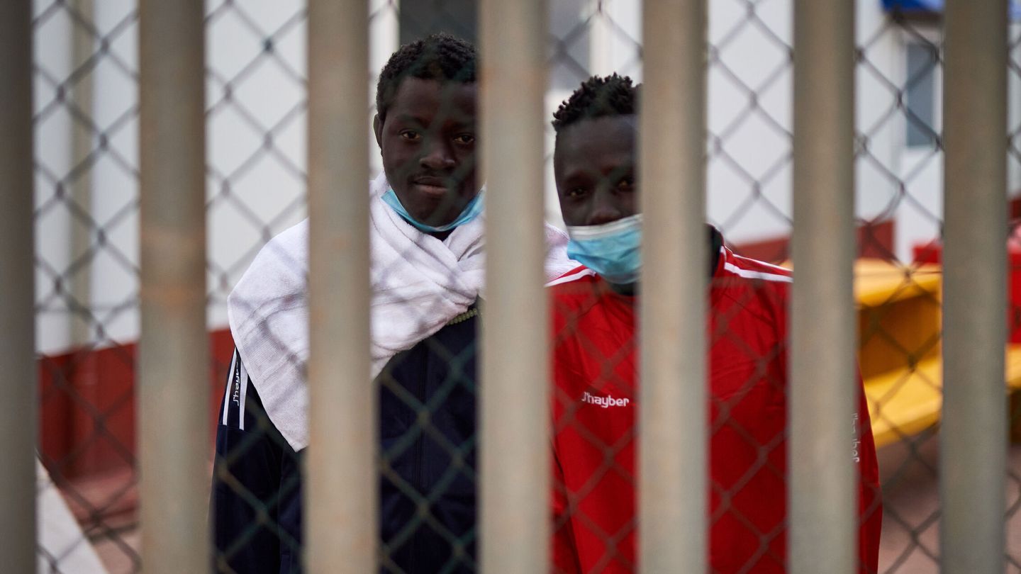 Dos inmigrantes detenidos en la valla de Melilla. (EFE)