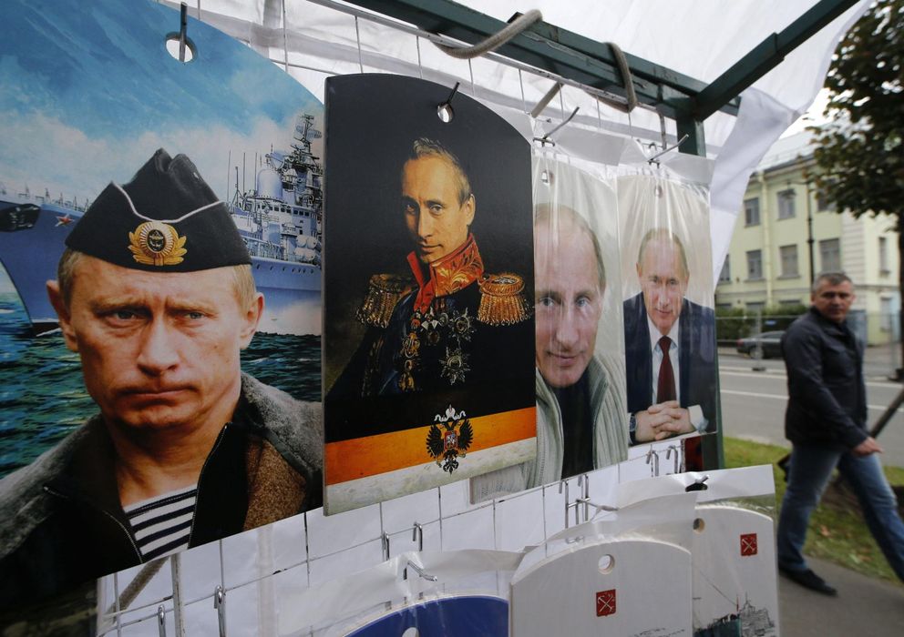 Foto: Un ruso camina ante una serie de pósters con imágenes del presidente ruso, Vladimir Putin, en San Petersburgo. (Reuters)
