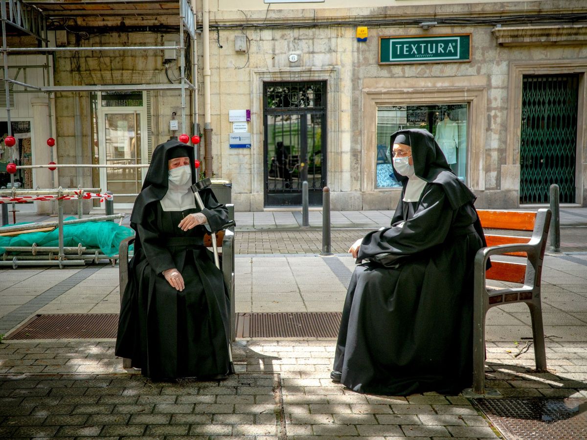 Foto: Dos monjas protegidas con mascarilla descansan en un banco de Santander. (EFE)