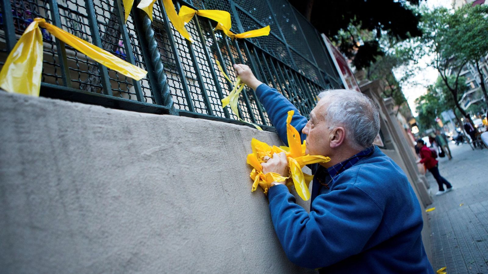 Foto: Un hombre retira lazos amarillos en Barcelona. (EFE)