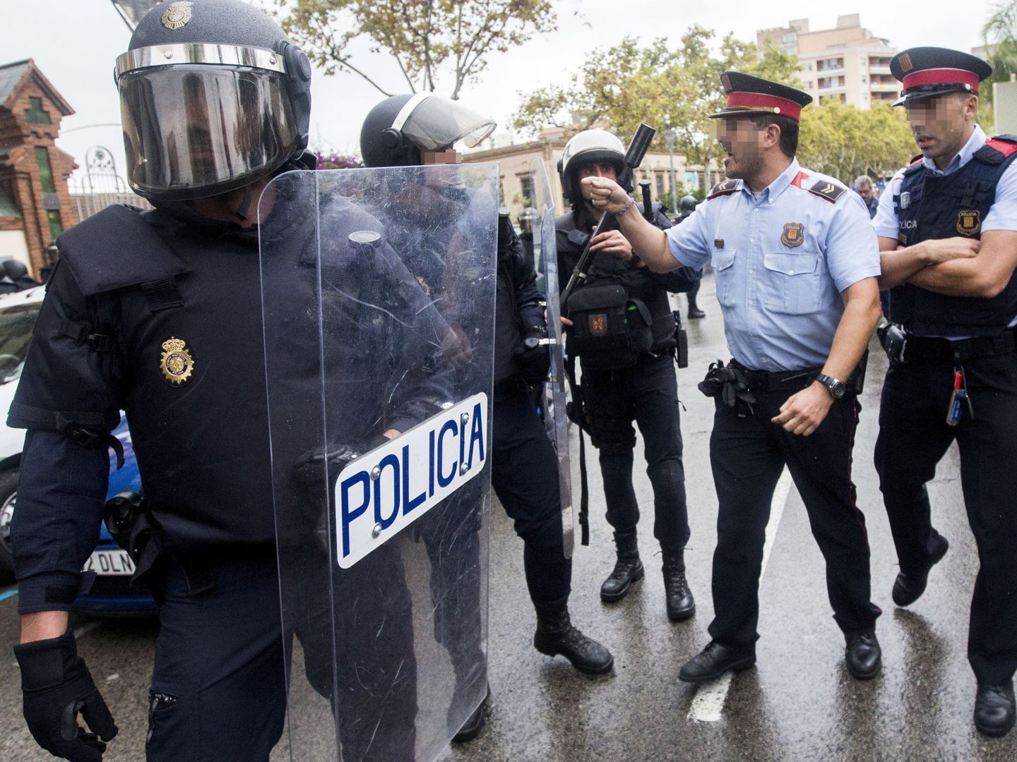 Agentes antidisturbios de la Policía Nacional y de los Mossos d'Esquadra discuten el 1 de octubre. (EFE)