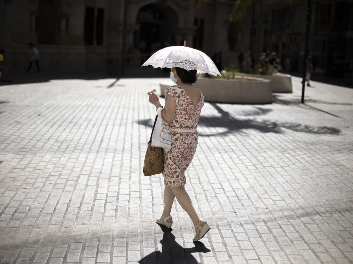 Foto: Una mujer se protege del calor en Valencia. (EFE/ Biel Aliño)