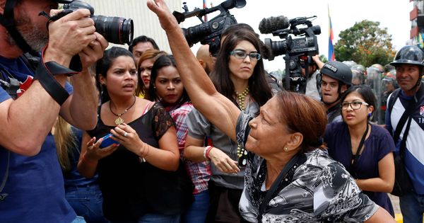 Foto: Una partidaria del Gobierno intenta arrebatarle la cámara a un fotógrafo durante enfrentamientos frente a la sede del Tribunal Supremo en Caracas, en marzo de 2017. (Reuters)