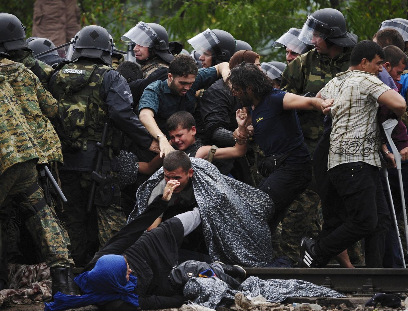 Refugiados intentan atravesar el cordón policial en Gevgelija, Macedonia (Reuters).