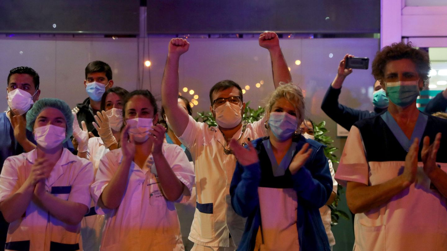 Médicos con mascarillas aplauden a las puertas de su hospital como cada día a las 20:00. (Reuters)