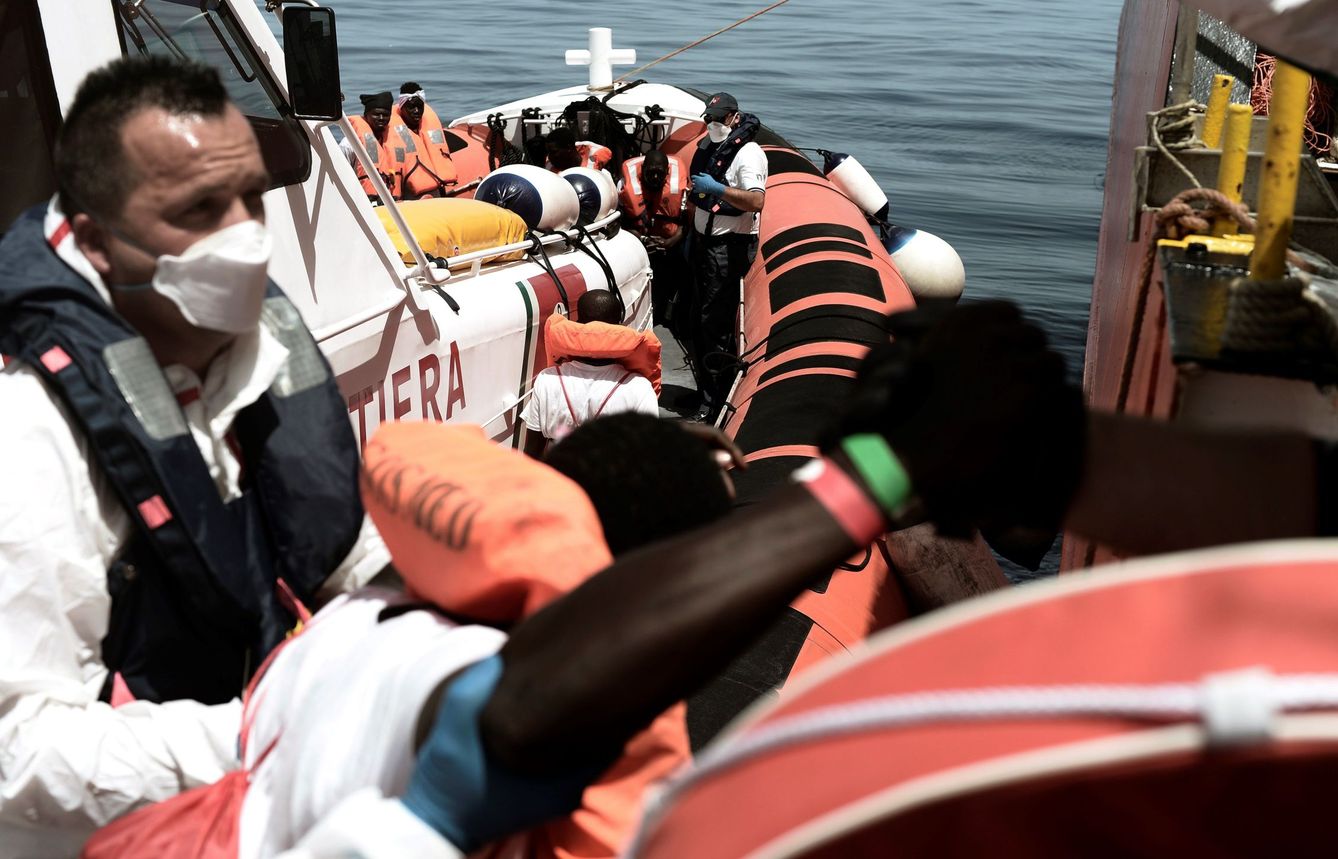 Uno de los 629 inmigrantes subsaharianos rescatados en el Mediterráneo por el buque Aquarius, es transferido a una patrullera de la Guardia Costera italiana. (EFE)