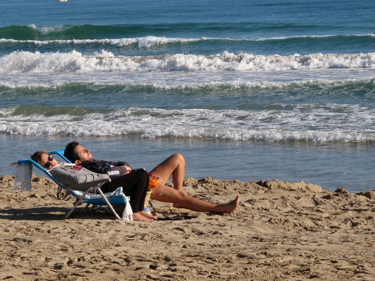 Foto: Una pareja descansa en la playa de La Pineda de Vila-Seca. (EFE/Jaume Sellart)