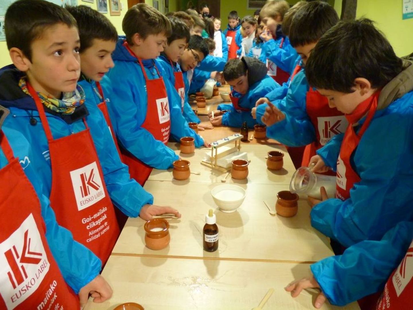 Niños aprenden a hacer cuajada en una visita escolar al caserío Gomiztegi de Oñati. (EC)